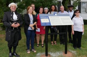 Dignitaries surround newly-unveiled historic marker
